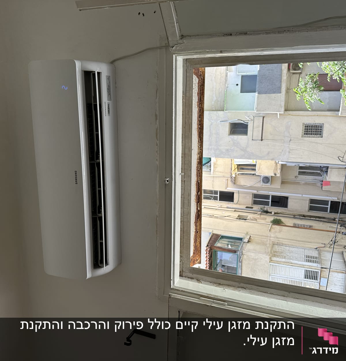 מזגן מותקן על קיר ליד חלון פתוח